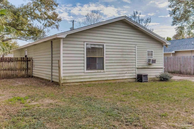 back of property featuring cooling unit, fence, and a lawn