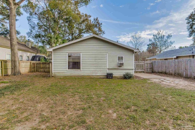 rear view of property with a yard, cooling unit, and a fenced backyard