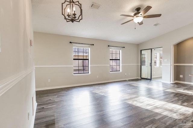 spare room with arched walkways, dark wood-type flooring, and visible vents