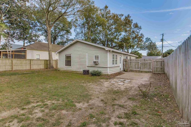 rear view of property with cooling unit, a fenced backyard, and a yard