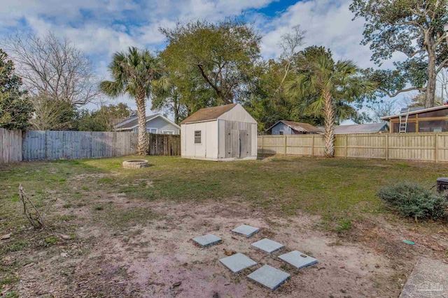 view of yard featuring an outbuilding, a storage shed, and a fenced backyard