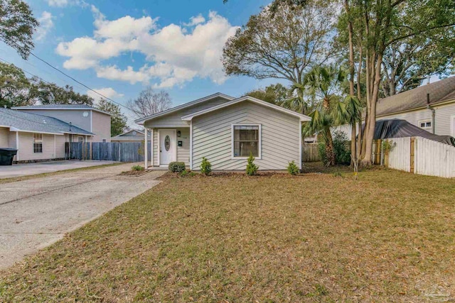 view of front of property featuring driveway, a front yard, and fence