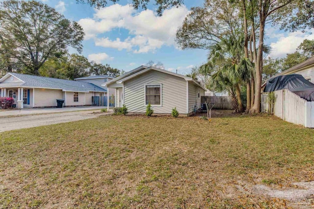 view of front of home with fence and a front lawn