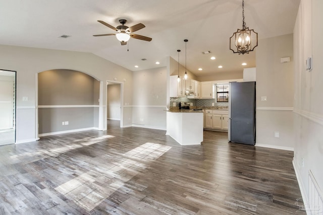 kitchen featuring stainless steel appliances, dark wood-type flooring, visible vents, open floor plan, and vaulted ceiling