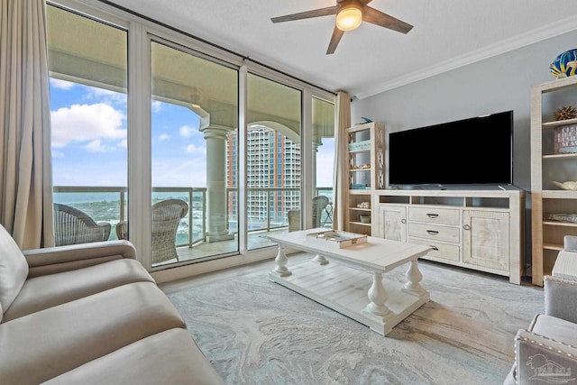 living room with a textured ceiling, ceiling fan, crown molding, a water view, and light hardwood / wood-style flooring