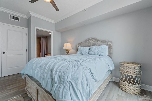 bedroom featuring hardwood / wood-style flooring, ceiling fan, and crown molding