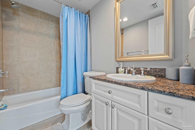 full bathroom featuring wood-type flooring, a textured ceiling, toilet, shower / bath combo with shower curtain, and vanity