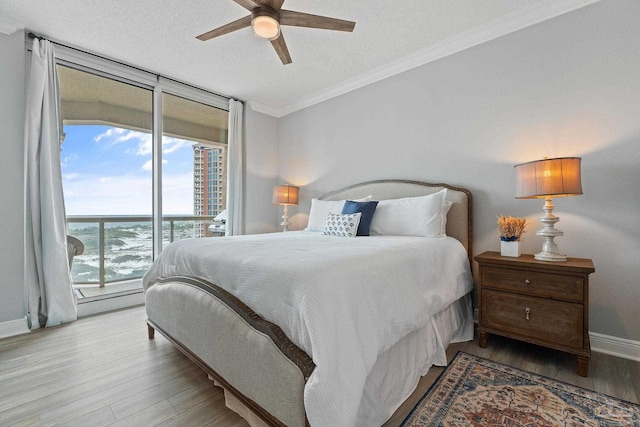 bedroom with floor to ceiling windows, ceiling fan, light wood-type flooring, a textured ceiling, and ornamental molding