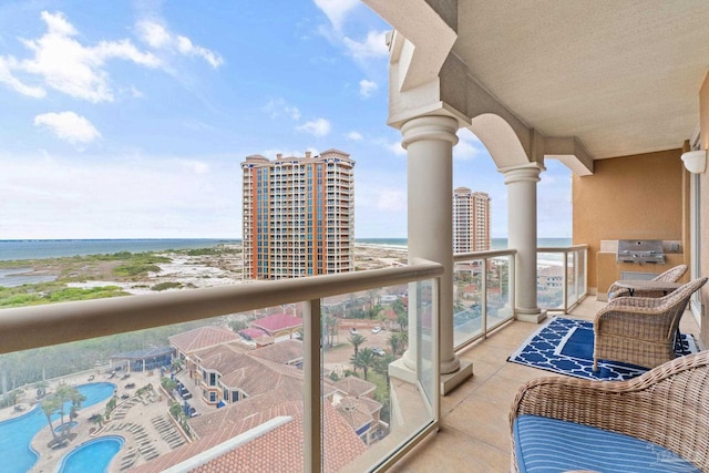 balcony featuring a water view and a beach view