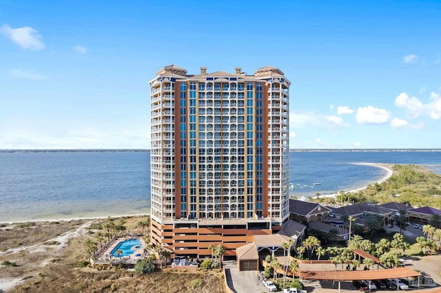 view of building exterior featuring a water view and a view of the beach