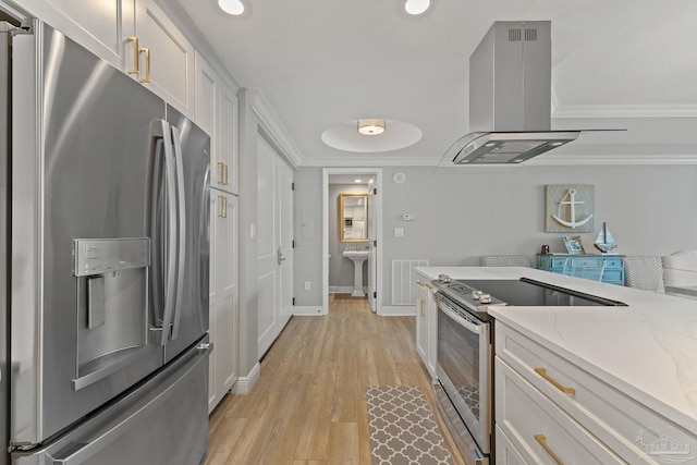 kitchen featuring appliances with stainless steel finishes, light wood-type flooring, light stone counters, white cabinets, and range hood