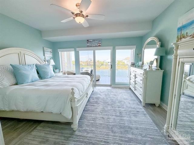 bedroom featuring a ceiling fan, multiple windows, light wood finished floors, and access to exterior