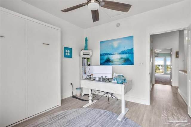 office featuring a ceiling fan, baseboards, and wood finished floors