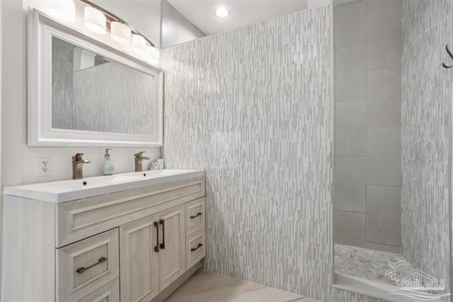 full bath featuring vanity and a tile shower