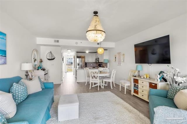 living area with visible vents and wood finished floors