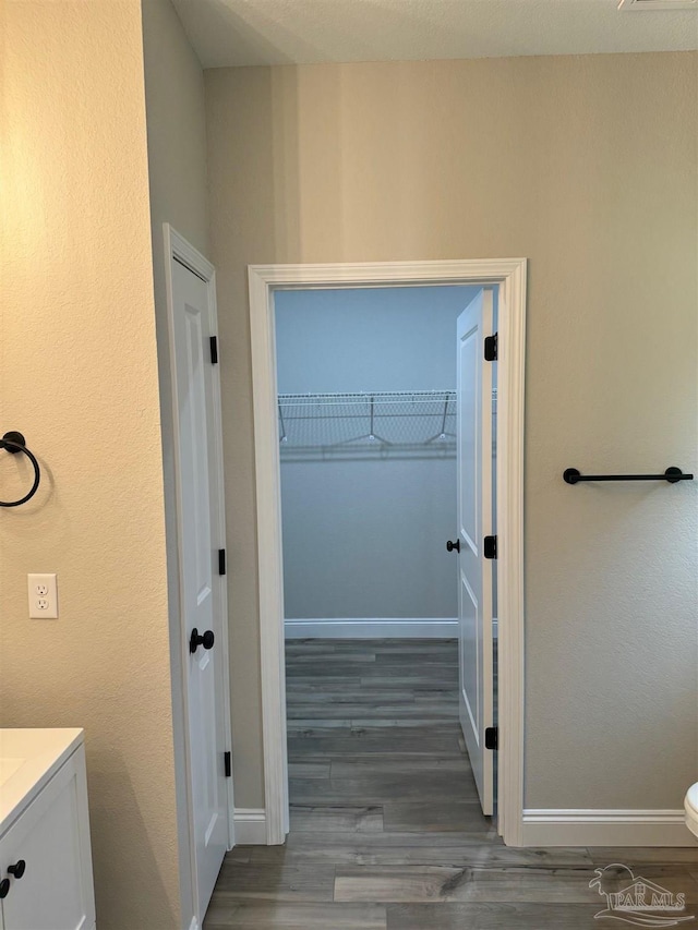 bathroom with hardwood / wood-style floors, vanity, and toilet