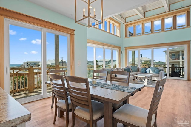800 Via Deluna Dr, Pensacola Beach, FL 32561 - dining room with beam ceiling, light wood-type flooring, and an inviting chandelier