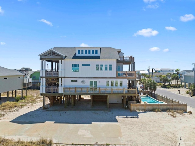 800 Via Deluna Dr, Pensacola Beach, FL 32561 - rear view of house featuring a carport, driveway, a balcony, and roof with shingles