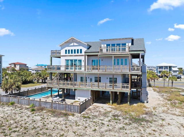 800 Via Deluna Dr, Pensacola Beach, FL 32561 - rear view of property with a fenced in pool, a shingled roof, and a balcony