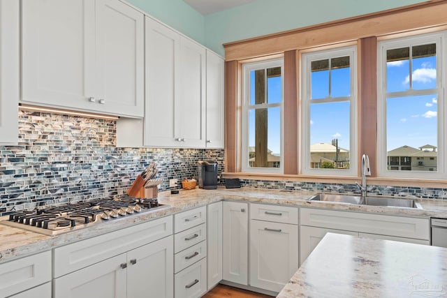 800 Via Deluna Dr, Pensacola Beach, FL 32561 - kitchen featuring a sink, light stone counters, tasteful backsplash, white cabinetry, and stainless steel gas stovetop