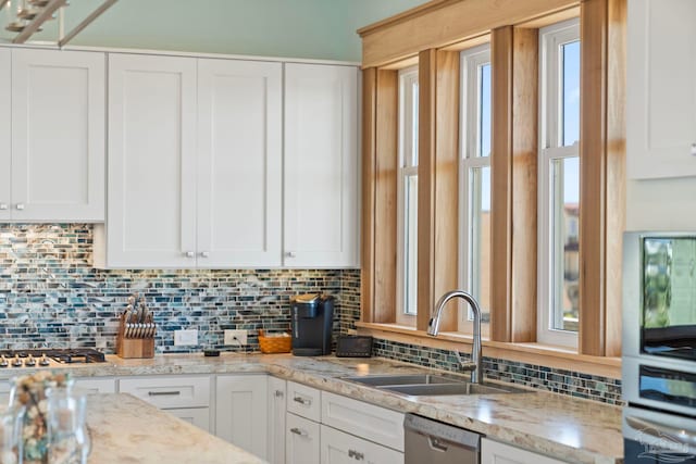 800 Via Deluna Dr, Pensacola Beach, FL 32561 - kitchen with a sink, light stone counters, backsplash, appliances with stainless steel finishes, and white cabinets