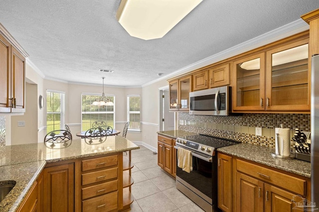 4621 Riley Rd, Milton, FL 32583 - kitchen with stainless steel appliances, brown cabinets, glass insert cabinets, light tile patterned floors, and ornamental molding