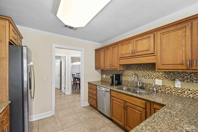 4621 Riley Rd, Milton, FL 32583 - kitchen with stainless steel appliances, crown molding, brown cabinetry, backsplash, and light tile patterned floors