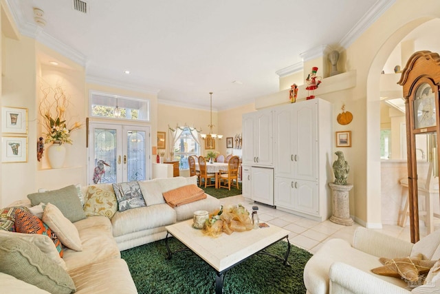 living room featuring light tile patterned floors, ornamental molding, and an inviting chandelier