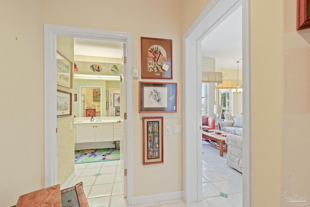 hall featuring sink and light tile patterned floors