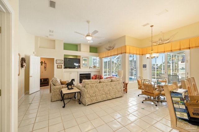 tiled living room featuring ceiling fan with notable chandelier and a healthy amount of sunlight