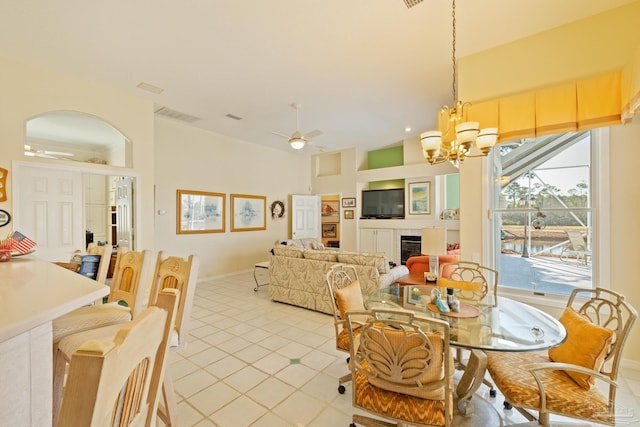 tiled dining room with ceiling fan with notable chandelier