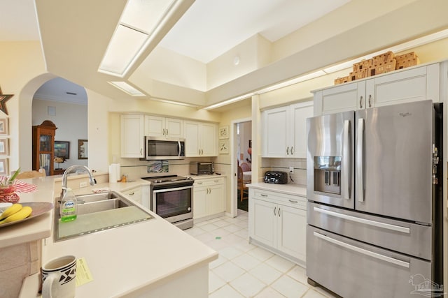 kitchen with white cabinets, sink, kitchen peninsula, and stainless steel appliances