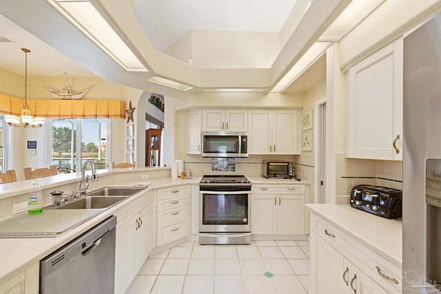 kitchen featuring sink, decorative backsplash, decorative light fixtures, stainless steel appliances, and a chandelier