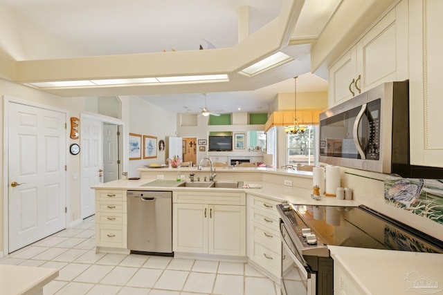 kitchen with ceiling fan with notable chandelier, sink, hanging light fixtures, light tile patterned floors, and appliances with stainless steel finishes