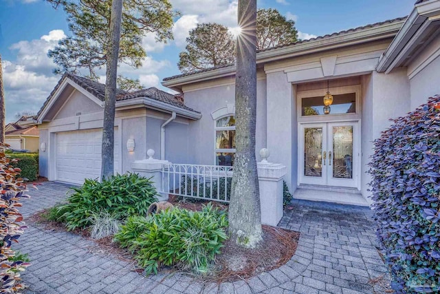 doorway to property featuring a garage and french doors