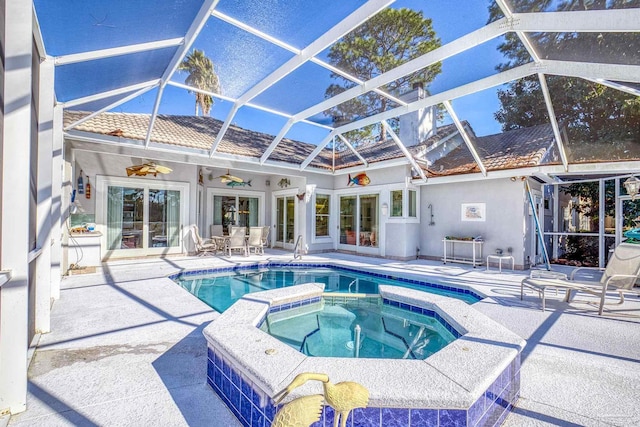 view of swimming pool featuring glass enclosure, ceiling fan, sink, a patio area, and an in ground hot tub