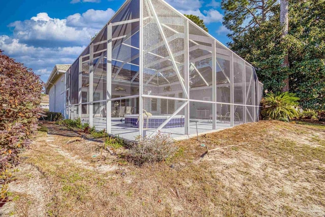 view of home's exterior with glass enclosure and a patio area