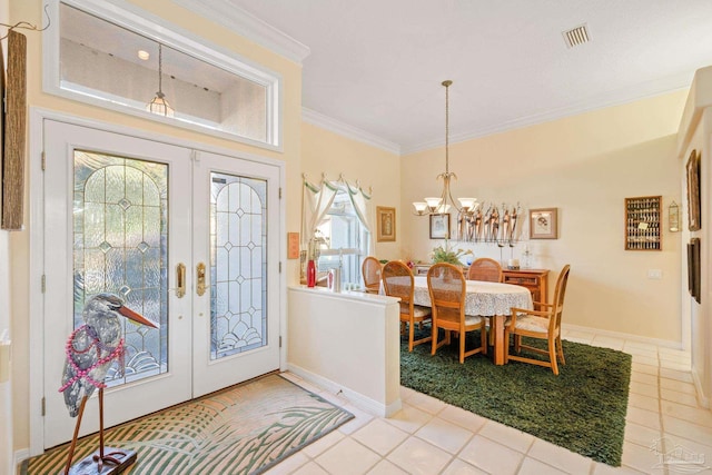 tiled foyer entrance featuring french doors, an inviting chandelier, and ornamental molding