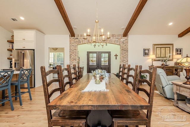 dining room with light wood-style floors, visible vents, beamed ceiling, and french doors