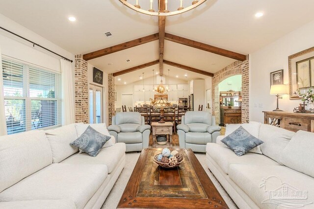 living room with lofted ceiling with beams, arched walkways, recessed lighting, brick wall, and visible vents