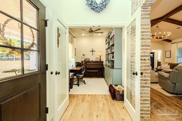 interior space featuring wood finished floors and ceiling fan with notable chandelier