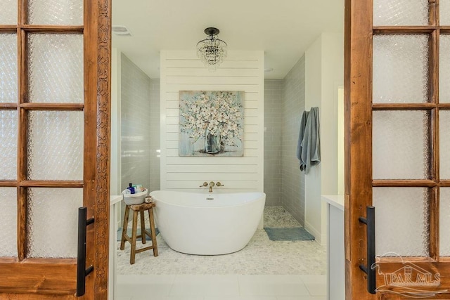 bathroom with tile patterned flooring and a freestanding tub