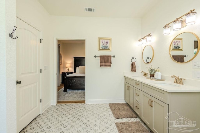 ensuite bathroom with double vanity, ensuite bath, a sink, and visible vents