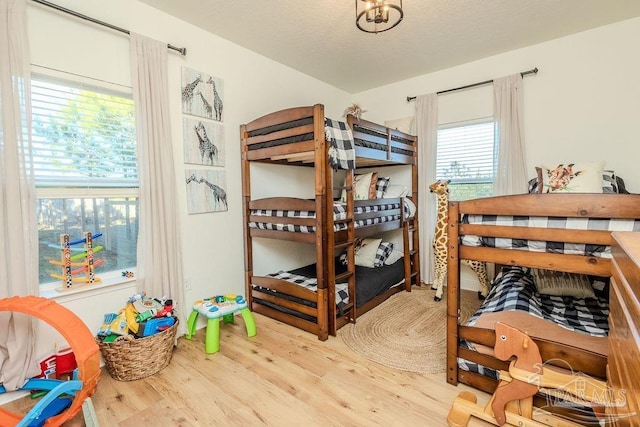 bedroom with a textured ceiling and wood finished floors