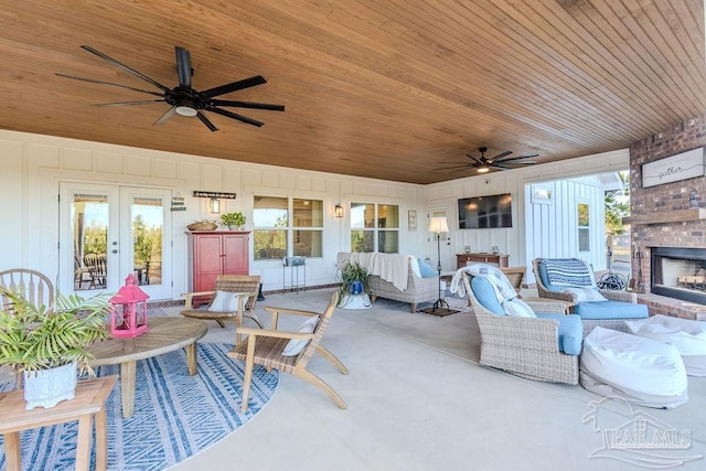 view of patio featuring an outdoor living space with a fireplace, a ceiling fan, and french doors