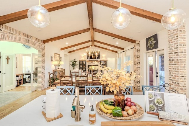 kitchen featuring lofted ceiling with beams, an inviting chandelier, and wood finished floors