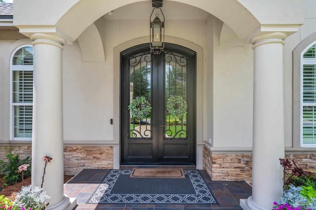 337 Grande Oaks Blvd, Cantonment, FL 32533 - view of exterior entry featuring stone siding, french doors, and stucco siding