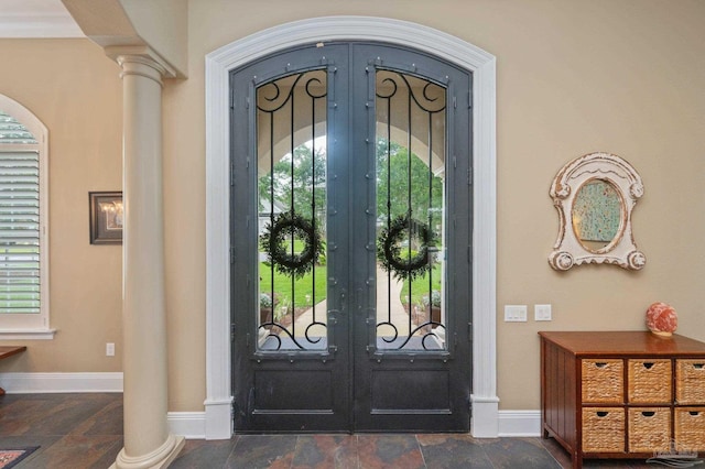 337 Grande Oaks Blvd, Cantonment, FL 32533 - foyer entrance with french doors, stone tile floors, baseboards, and decorative columns