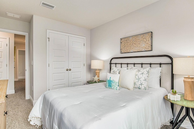 carpeted bedroom with a closet, visible vents, and baseboards