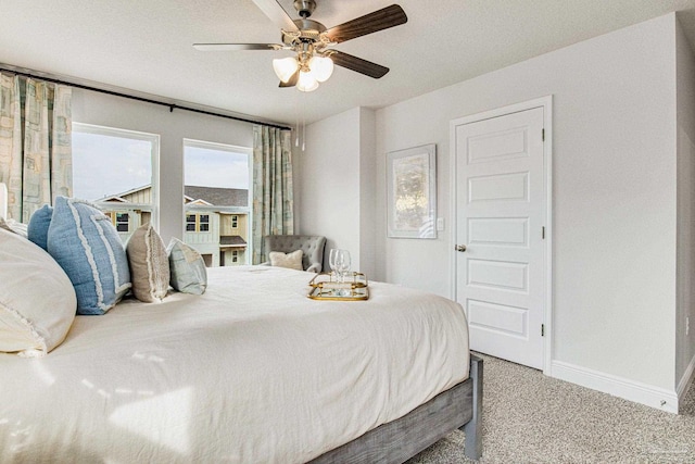 carpeted bedroom with baseboards and a ceiling fan